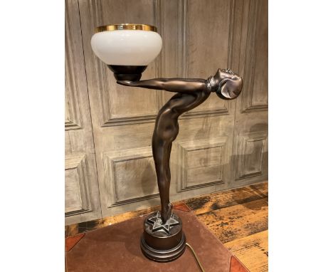An Art Deco style figural lamp on circular plinth with star design with opaque shade also with another lamp. 