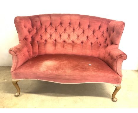 An early 20th century curved wing back sofa with button back detail. W x 150cm H x 104 cm D x 79cms.