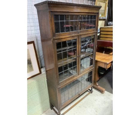 A Globe Wernicke oak sectional bookcase with leaded glass, tradition Globe Wernicke opening doors top and bottom with cupboar