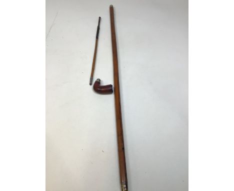 A walking stick with a smoking pipe 