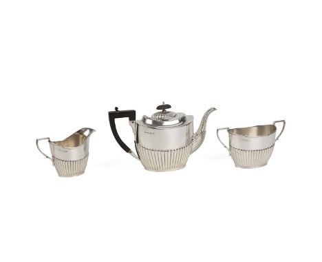 Silver three piece tea set comprising teapot, milk jug and sugar bowl all with ribbed bodies, the teapot with ebonised finial