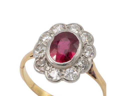 Ruby and diamond cluster ring, unmarked, the oval cut enclosed by ten brilliant cuts estimated as totalling approximately 0.8