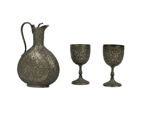 Indian silver carafe, along with two matching goblets, the carafe with curved cobra handle; each piece heavily decorated thro