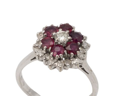 Ruby and diamond 18ct white gold cluster ring, the central brilliant cut enclosed by six rubies, in turn enclosed by small si