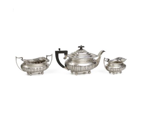 Silver three piece tea set comprising milk jug, sugar bowl and tea pot with gadroon decoration and ribbed bodies, the teapot 