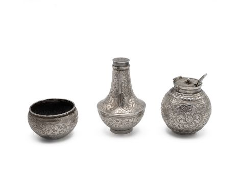 A three piece white metal cruet set possibly Indian, comprising a salt cellar (with spoon), mustard pot and pepper shaker all