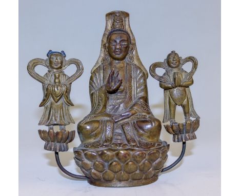 Guanyin auf Lotosthron sitzend  China, wohl 18. Jh. Bronze, dunkel patiniert. Die rechte Hand im Lehrgestus erhoben. Zu Seite
