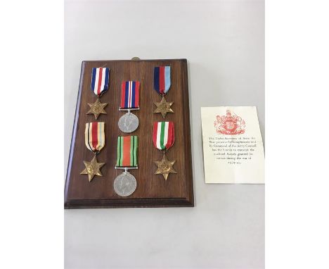 Collection of six mounted WW11 Medals Mounted on wooden panel with paperwork 