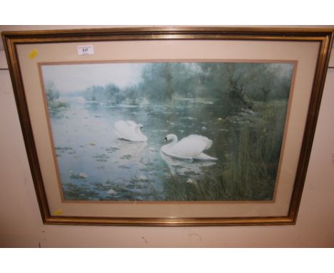 A gilt framed print depicting swans on a lake