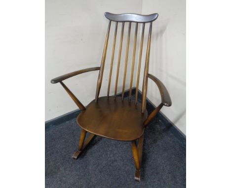 An Ercol elm and beech spindle back rocking chair in antique finish.