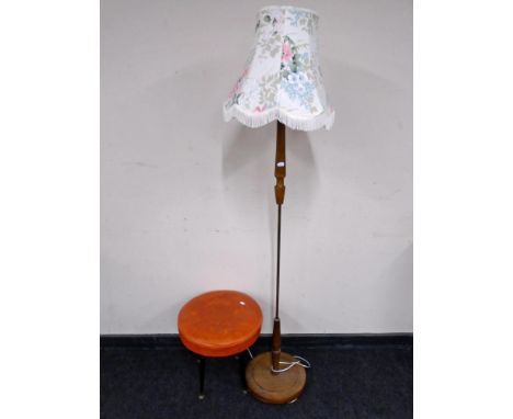 A mid-20th century standard lamp with shade together with a footstool on raised legs upholstered in orange vinyl.