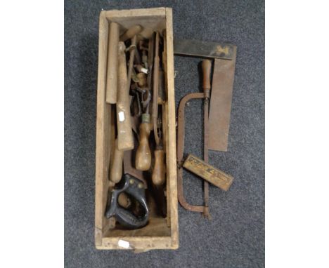 An antique pine drawer containing vintage hand tools.