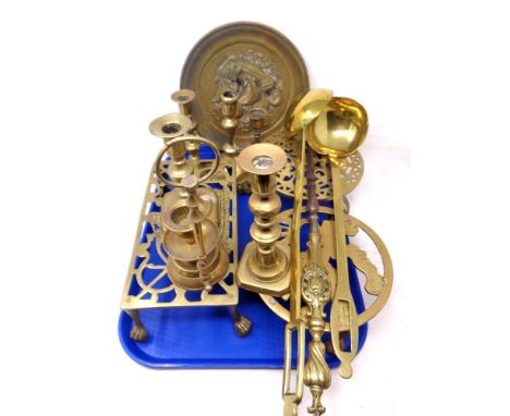 A tray containing antique and later brass ware including trivets, candlesticks, ladle etc.