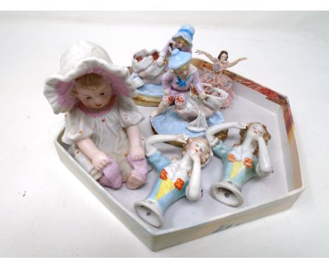 Antique ceramics including a bisque figure of a baby, a pair of china dolly tops, a Dresden figure of a girl with a sugar-spu