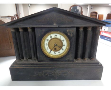 A 19th century black slate mantel clock with enamelled brass dial.