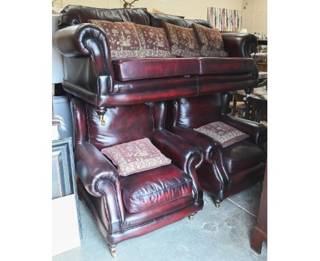 A Thomas Lloyd maroon leather sofa with shaped back and scroll arms, turned mahogany front legs with brass casters, 190 cm wi