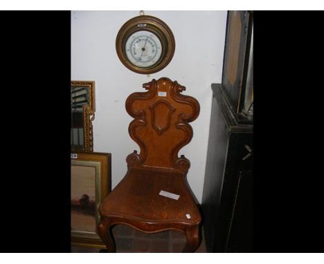 A Victorian carved oak hall chair with cabriole legs, together with a circular wall barometer  
