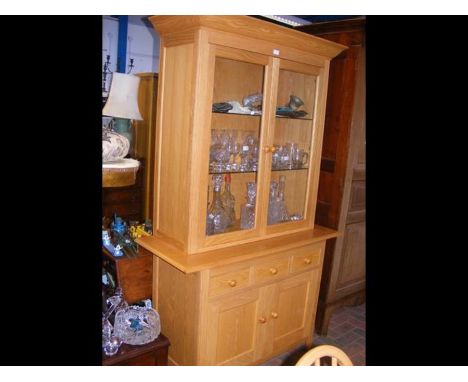 A light oak display cabinet with upper section and three drawers and cupboard below - width 116cms