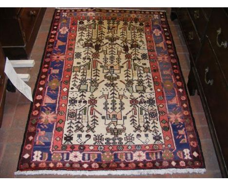 A Persian light ground bordered rug with stylized design - 165cm x 105cm 