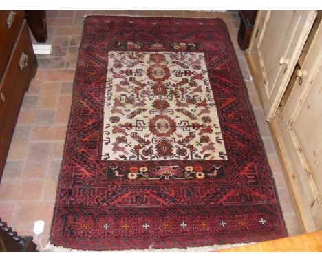 A Middle Eastern light ground rug with red border and animal design - 150cm x 90cm 