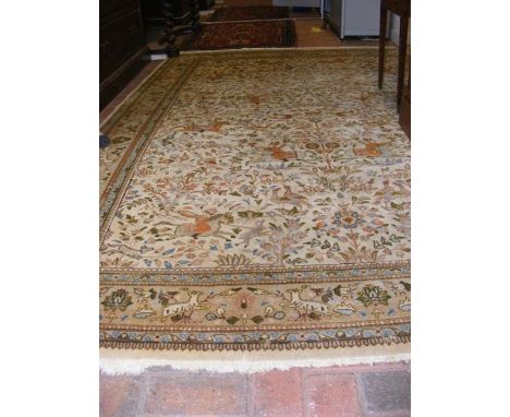 A Persian light ground bordered carpet with hunting scene - 290cm x 190cm - signs of wear, including hole to centre CONDITION