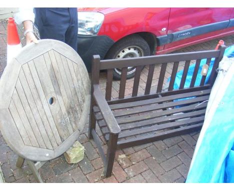 A wooden garden bench and teak circular garden table 