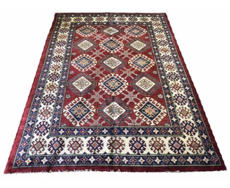 KAZAK CARPET, 251cm x 166cm, rows of geometric medallions on a ruby field within corresponding borders.