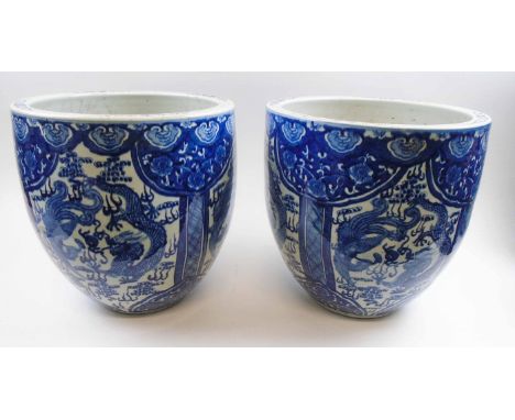 PAIR OF CHINESE CERAMIC PLANTERS, each decorated blue/white dragon designs in panels, 35cm diam x 35.5cm H. (2)