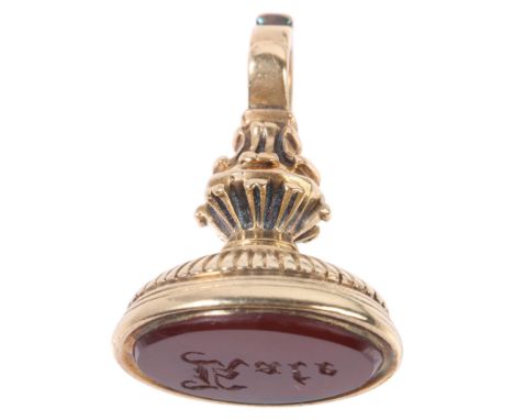An Antique Victorian 15ct gold carnelian 'Kate' seal fob, the oval carnelian intaglio carved in Gothic script, in foliate mou