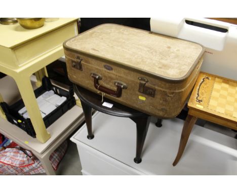 A vintage suitcase and a circular occasional table 
