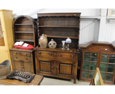 An oak dresser enclosed by linen fold panel doors