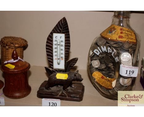 A carved wooden Black Forest style thermometer with bear decoration