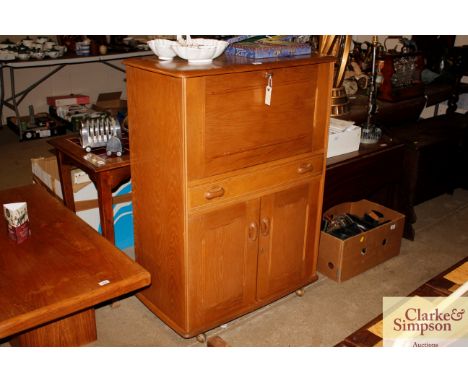 An Ercol style light wood cocktail cabinet