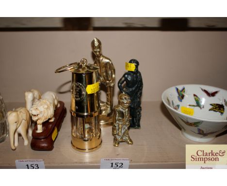 A miniature brass miners lamp; two brass figures; and another 