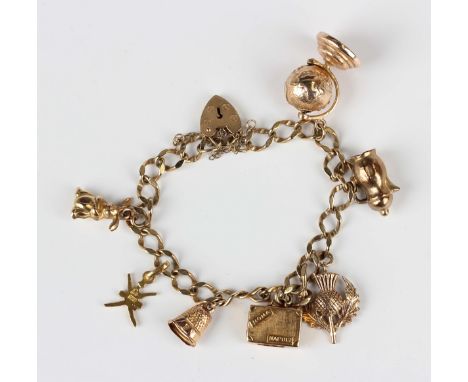 A 9ct gold faceted curblink charm bracelet with a 9ct gold heart shaped padlock clasp, fitted with seven mostly gold pendants