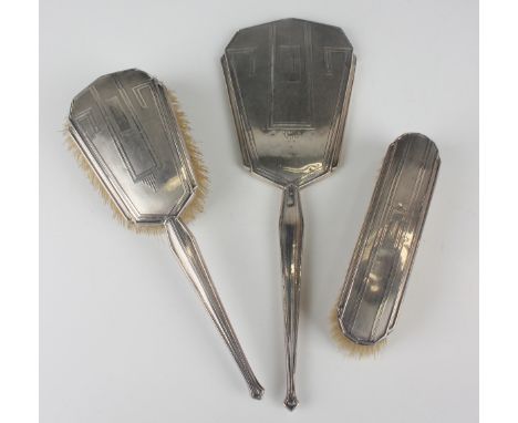 A George V silver mounted three-piece dressing table set, engine turned with geometric decoration, comprising hand mirror, ha