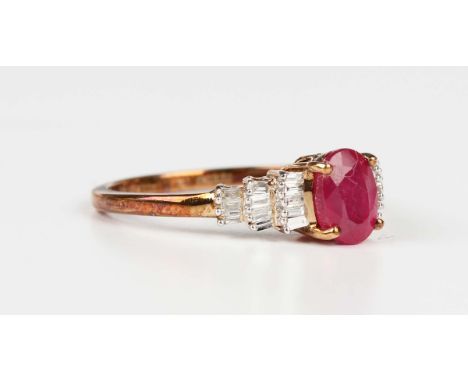 A 9ct gold, treated ruby and diamond ring, claw set with the oval cut  treated ruby between baguette cut diamond three tiered