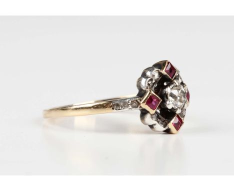 A gold, diamond and ruby ring, 1920s, claw set with the principal cushion cut diamond within a surround of four square cut ru