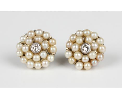 A pair of diamond and seed pearl circular earstuds, each collet set with a circular cut diamond within a two row surround of 
