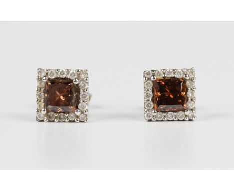 A pair of 18ct white gold, diamond and brown tinted diamond earstuds, each mounted with a square cut brown tinted diamond wit