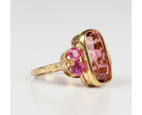 A gold ring, collet set with an oval cut pink tourmaline between pink gem set two stone sides, with rose cut diamond two ston