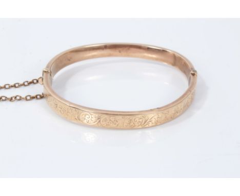 Gold (9ct) bangle with engraved floral scroll decoration and safety chainCondition report: Weight 8.3g. Bangle is slightly be