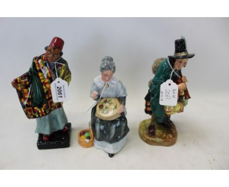 Three Royal Doulton figures - Carpet Seller HN1464, The Mask Seller HN2103 and Embroidering HN2855