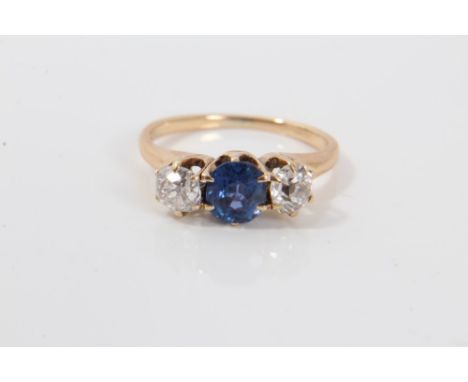 Diamond and Sapphire three stone ring with a central round mixed cut blue sapphire flanked by an old cut diamond to each side