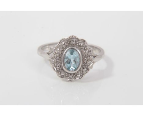 White gold (18ct) aquamarine and diamond cluster ring with an oval mixed cut aquamarine surrounded by four brilliant cut diam