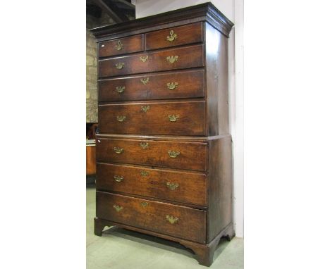 A Georgian oak chest on chest fitted with an arrangement of six long and two short graduated drawers with dentil and reed mou