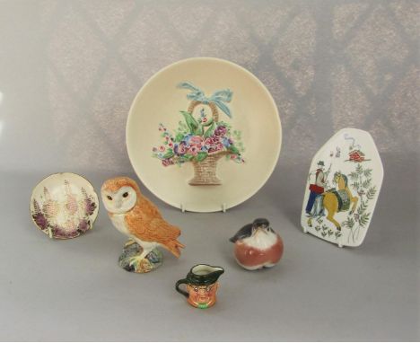 A Clarice Cliff cream ground wall plate with relief moulded and painted flower basket and ribbon detail, with printed mark to