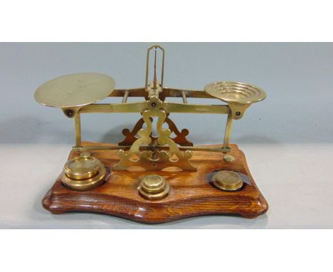 A set of Victorian brass and oak balance postal scales by Sampson Mordan &amp; co compete with seven graduated weights 