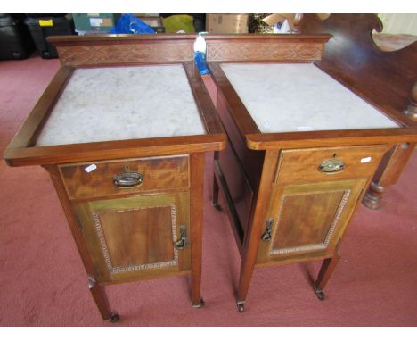 A pair of Edwardian mahogany bedside/lamp tables, the shallow raised backs with blind fretwork detail over inset marble tops,