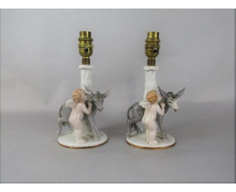 A pair of Bavarian table lamp bases modelled as cherubs and donkeys, with printed marks to base and impress numbers 5183, 16.